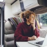 Adult woman using laptop in the campground