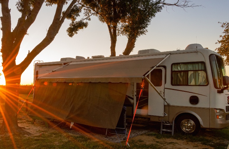 Rv motorhome camping with trees and sunburst