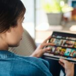 Woman Choosing Movie For Streaming On Tablet Computer