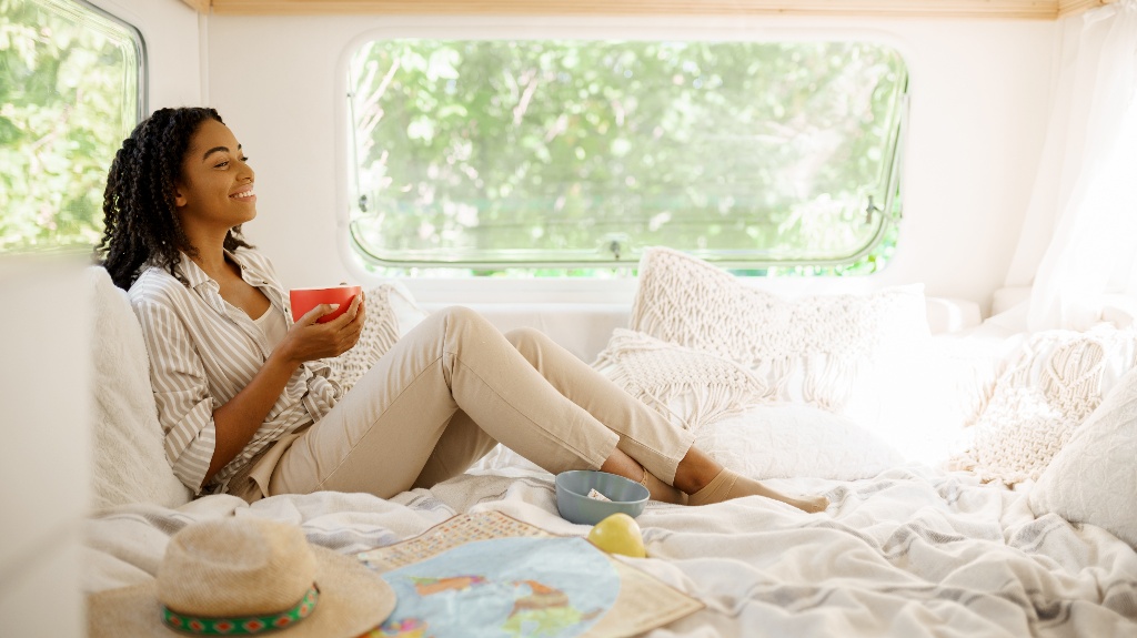 Young woman relax in bed, camping in a trailer