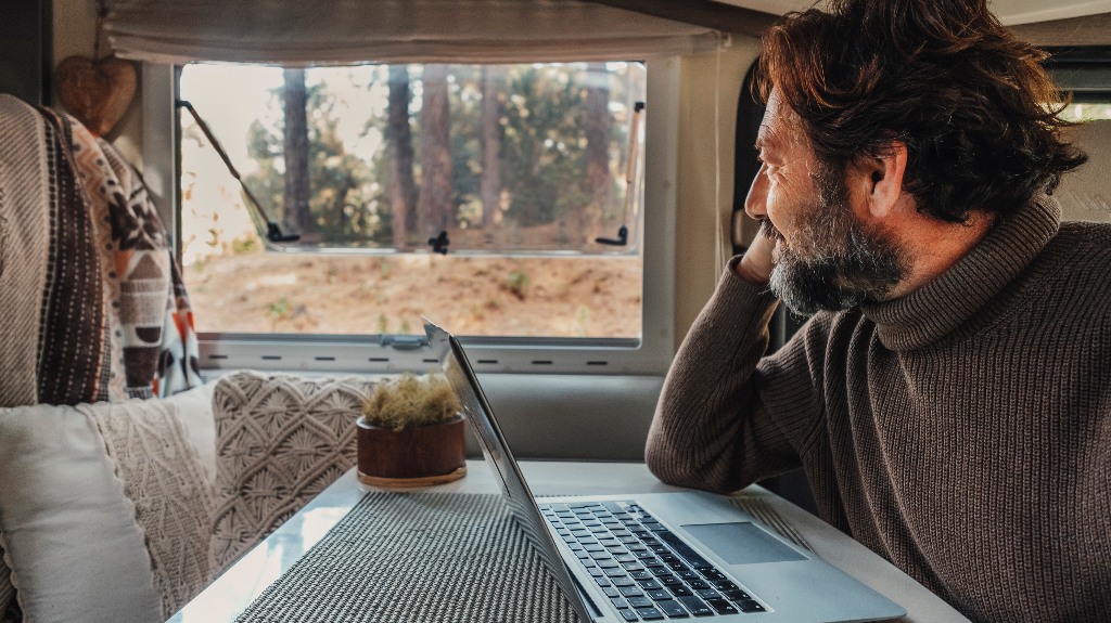 mature man working on laptop in rv park