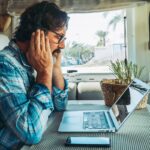 Adult man sitting at the desk using laptop