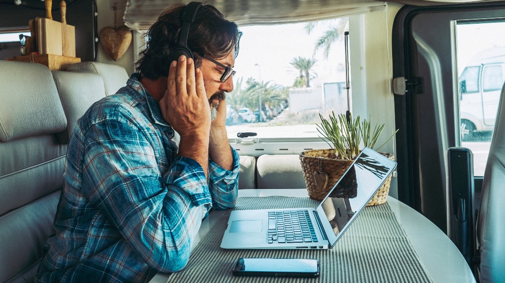 Adult man sitting at the desk using laptop